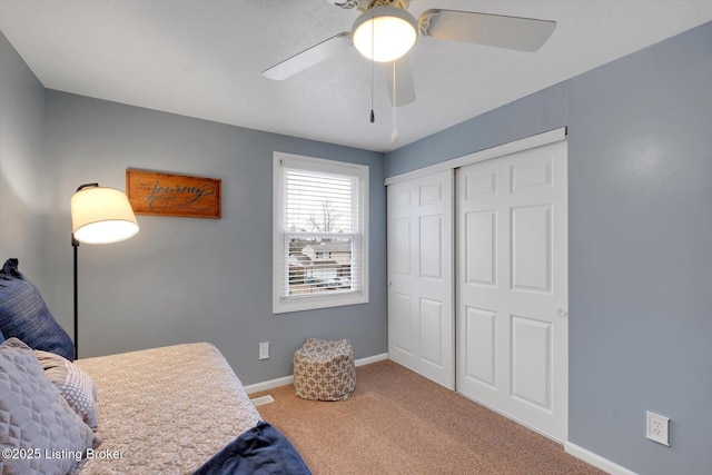 bedroom with a closet, ceiling fan, baseboards, and carpet floors