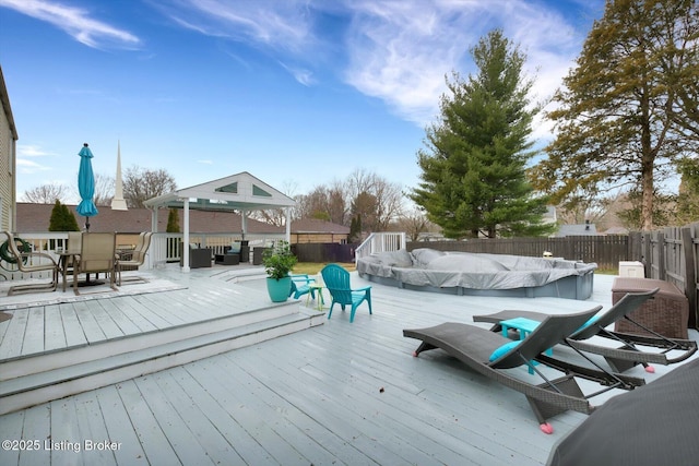 wooden deck featuring a fenced in pool, outdoor dining area, and a fenced backyard