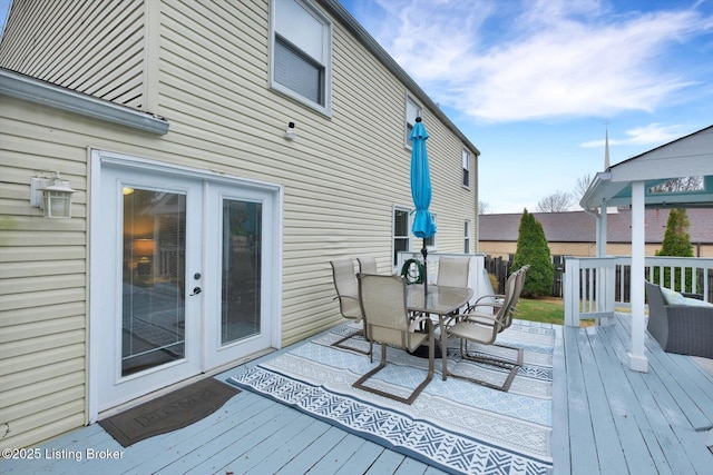 wooden terrace featuring outdoor dining area and french doors