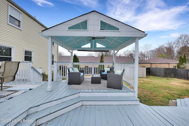 deck featuring fence, a gazebo, outdoor lounge area, a yard, and a ceiling fan