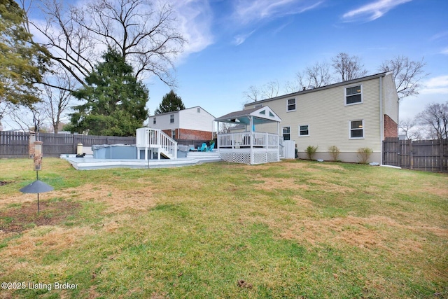 rear view of house with a yard, a fenced backyard, and a wooden deck