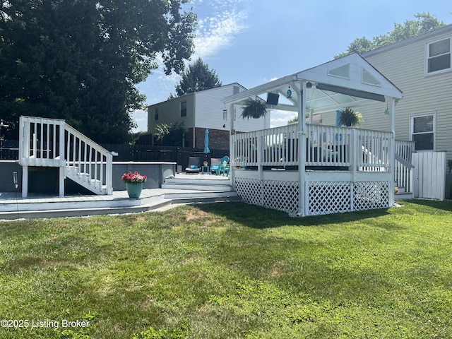 rear view of property with a yard and a wooden deck