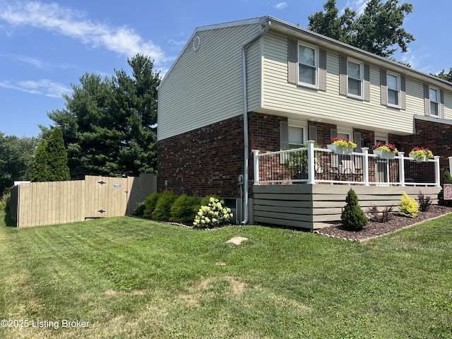 view of front of house with a front lawn, a gate, fence, and brick siding