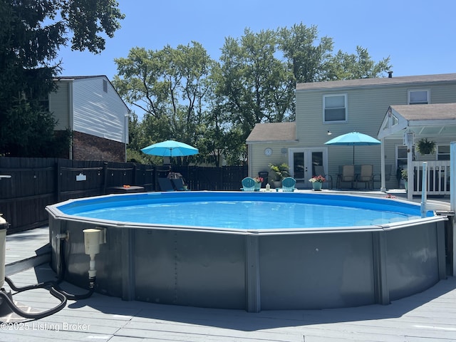 view of swimming pool featuring a fenced in pool, french doors, and a fenced backyard