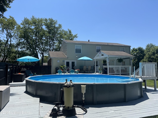 view of pool with a deck, a fenced in pool, fence, and french doors