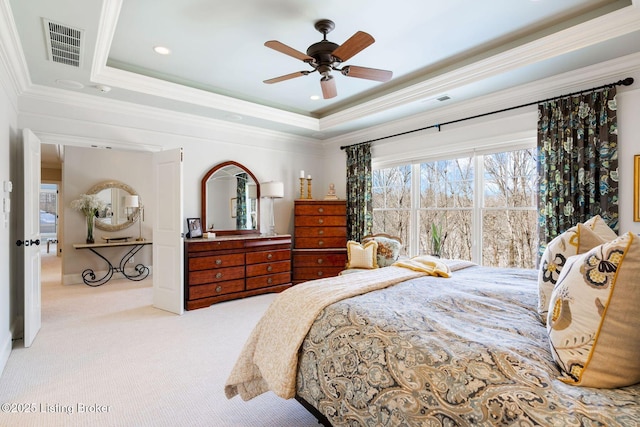 bedroom with carpet, a raised ceiling, visible vents, and crown molding