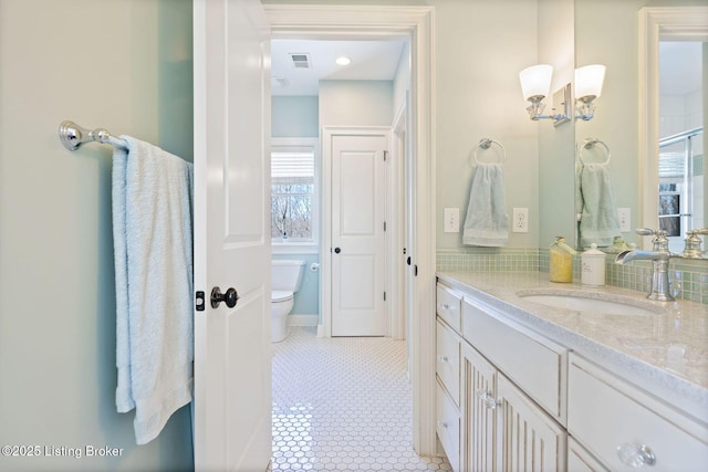 bathroom featuring visible vents, vanity, toilet, and tile patterned floors