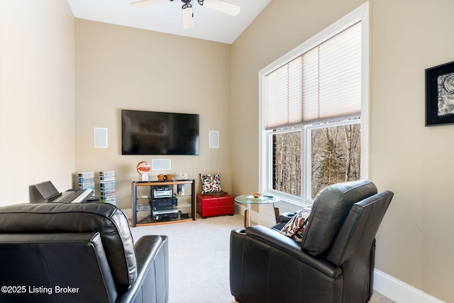 carpeted living room featuring a ceiling fan and baseboards