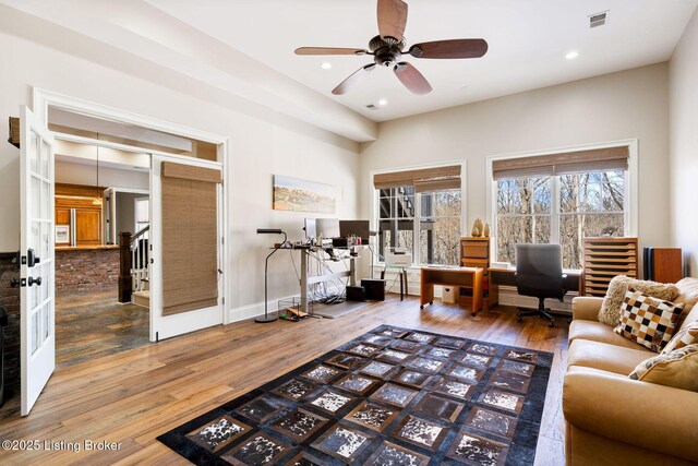 living area with baseboards, visible vents, wood finished floors, and recessed lighting