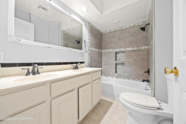 bathroom with tile patterned floors, toilet, washtub / shower combination, and a sink