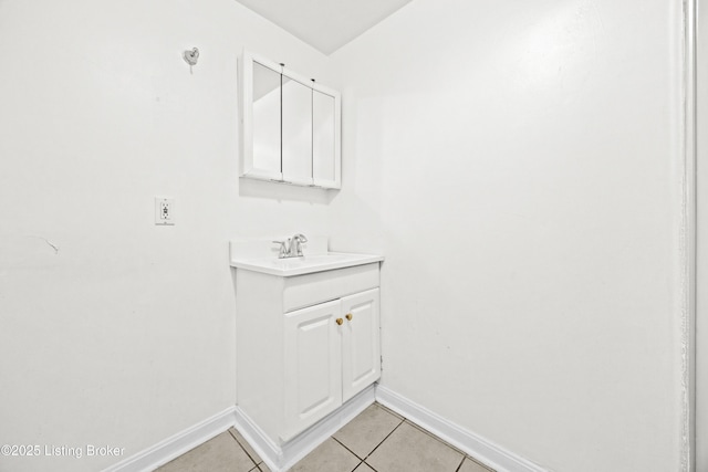 bathroom with baseboards, vanity, and tile patterned flooring