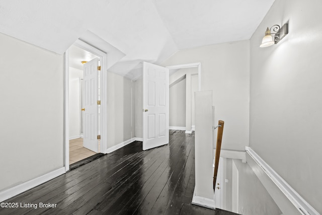 interior space with vaulted ceiling, baseboards, and hardwood / wood-style floors