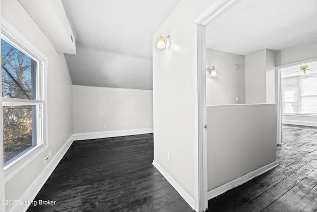 bonus room featuring baseboards, wood finished floors, and vaulted ceiling