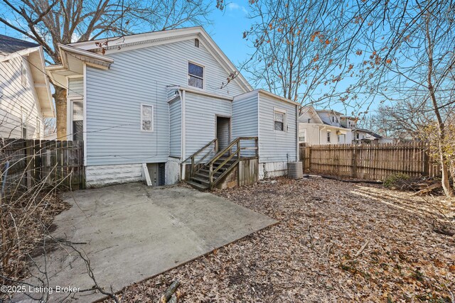 rear view of house featuring a patio area, fence, and central AC