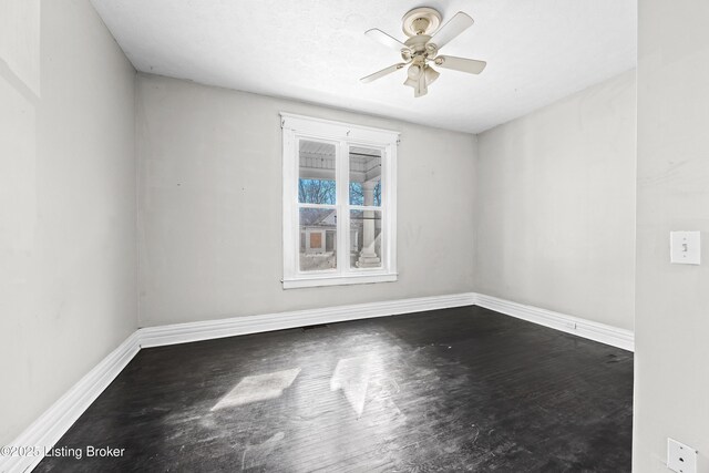 empty room with baseboards, wood finished floors, and a ceiling fan
