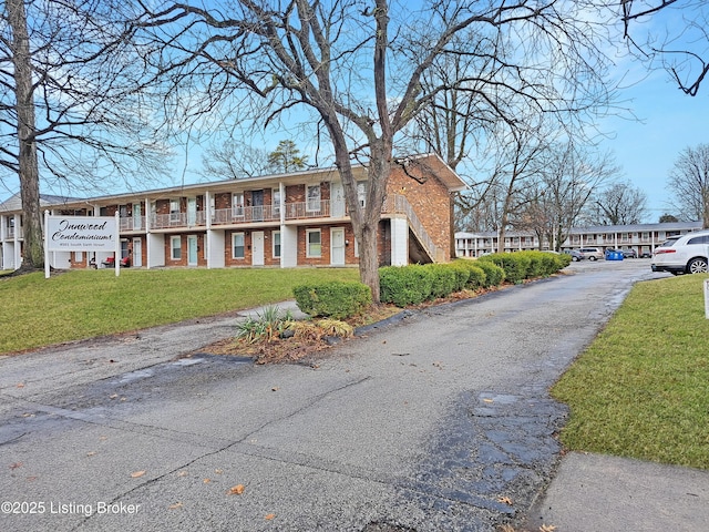 exterior space featuring a front yard and brick siding