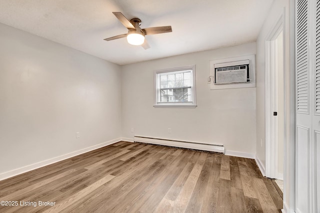 unfurnished bedroom featuring a baseboard heating unit, a closet, light wood finished floors, and a wall mounted AC