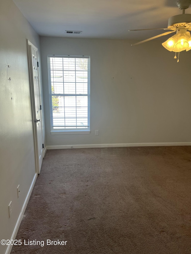 empty room featuring carpet floors, baseboards, and visible vents