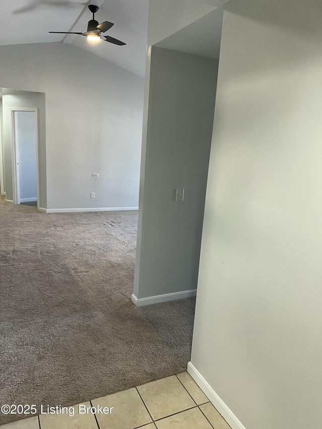 spare room with light tile patterned floors, lofted ceiling, a ceiling fan, light carpet, and baseboards