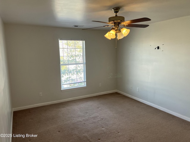 carpeted spare room featuring ceiling fan, visible vents, and baseboards