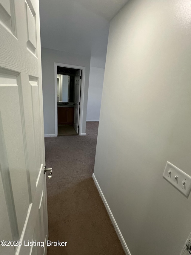 hall featuring carpet and baseboards