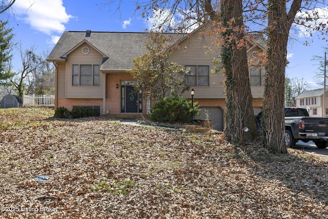 view of front of home featuring a garage, brick siding, roof with shingles, and fence