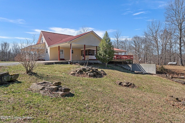 view of front of home with metal roof and a front lawn