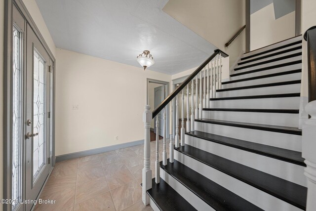 stairs with french doors and baseboards