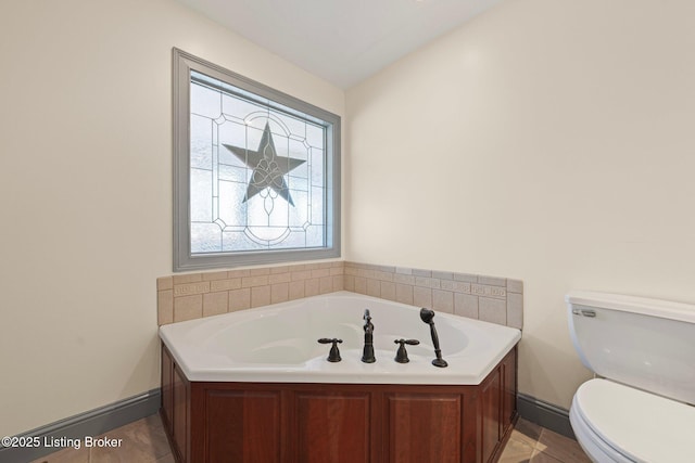 bathroom featuring toilet and a garden tub