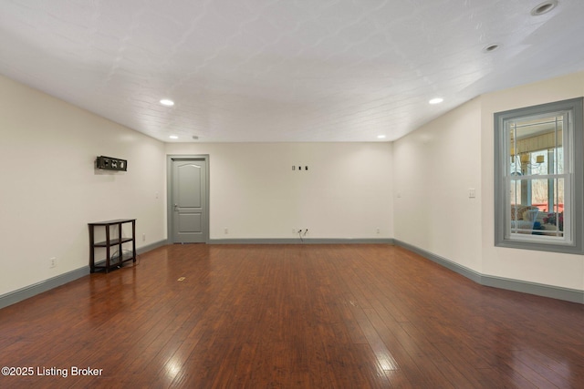 empty room featuring recessed lighting, baseboards, and hardwood / wood-style flooring