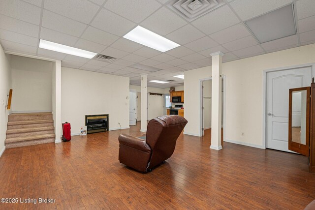 living area featuring stairway, wood finished floors, visible vents, and ornate columns