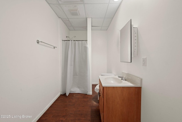 full bathroom with a shower with shower curtain, a drop ceiling, wood finished floors, and vanity