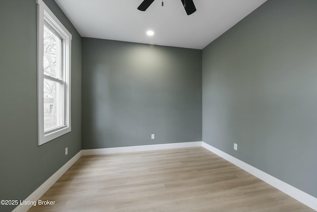 unfurnished room with a healthy amount of sunlight, light wood-type flooring, and baseboards