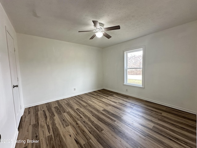 empty room with a textured ceiling, dark wood finished floors, a ceiling fan, and baseboards