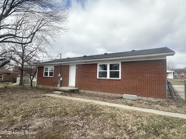 back of property featuring fence and brick siding