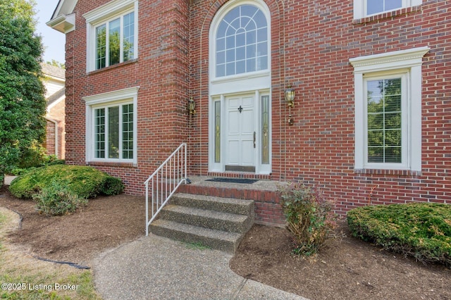 doorway to property featuring brick siding