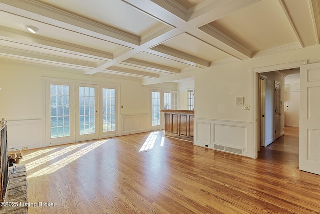 unfurnished living room featuring light wood-style flooring, visible vents, coffered ceiling, and beamed ceiling