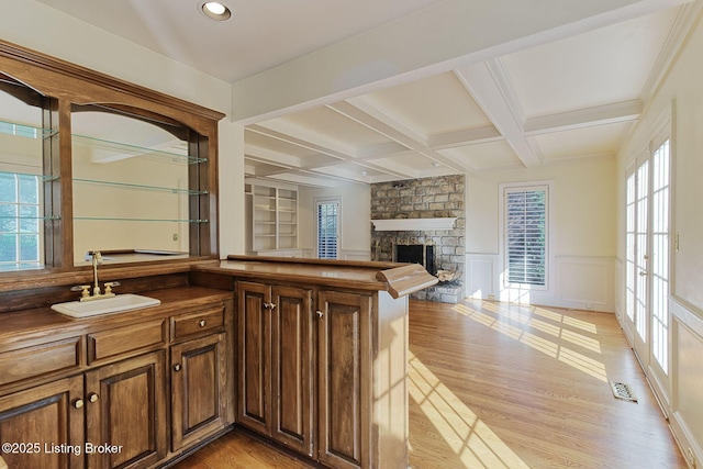 interior space featuring visible vents, coffered ceiling, a sink, and light wood-style flooring