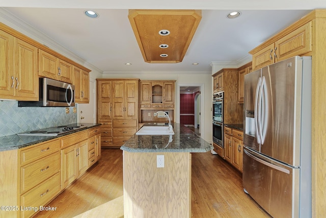 kitchen with light wood-style floors, a center island with sink, stainless steel appliances, and a sink