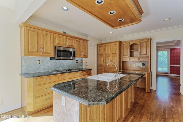 kitchen with electric stovetop, wood finished floors, a sink, ornamental molding, and stainless steel microwave