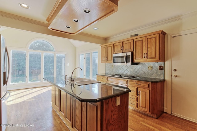 kitchen featuring appliances with stainless steel finishes, brown cabinets, light wood-style floors, and decorative backsplash