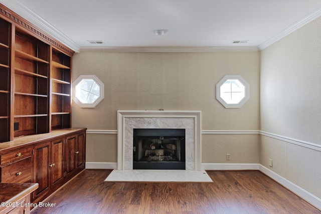 unfurnished living room featuring hardwood / wood-style flooring, visible vents, and ornamental molding