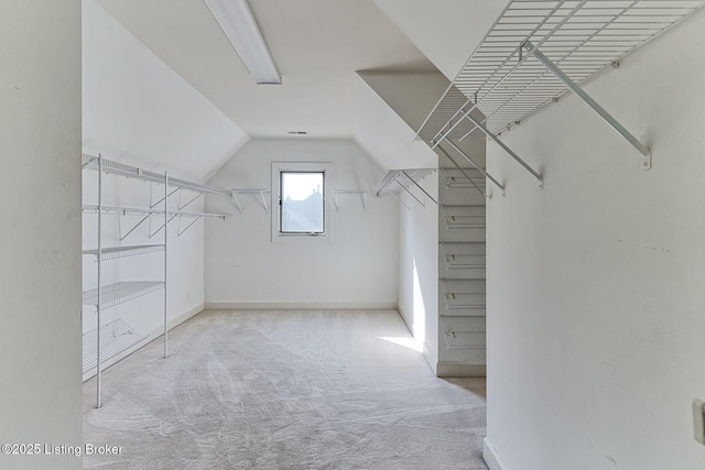 walk in closet featuring carpet floors and lofted ceiling