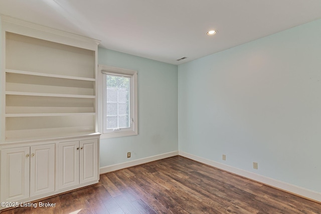 empty room with baseboards, visible vents, dark wood-style flooring, and recessed lighting