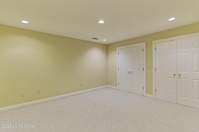 unfurnished bedroom featuring multiple closets, recessed lighting, carpet floors, and baseboards