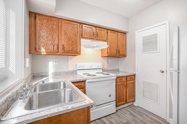 kitchen with light countertops, white appliances, visible vents, and under cabinet range hood