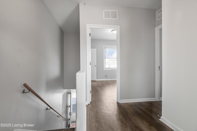 corridor featuring an upstairs landing, wood finished floors, visible vents, and baseboards