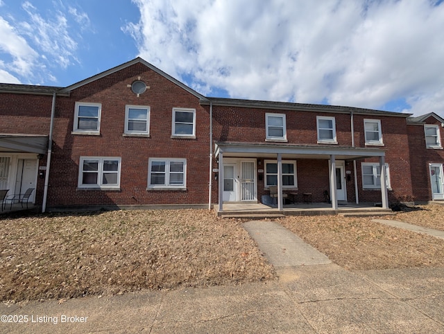 multi unit property featuring covered porch and brick siding