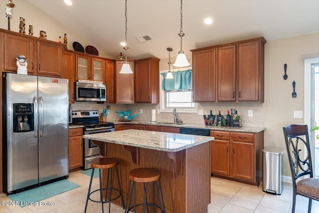 kitchen featuring appliances with stainless steel finishes, brown cabinets, visible vents, and tasteful backsplash