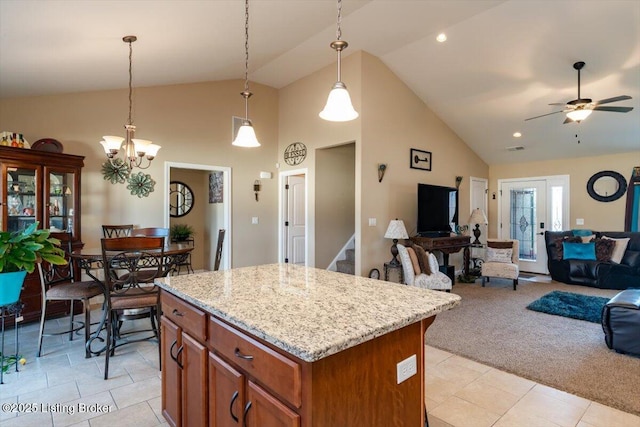 kitchen with brown cabinetry, open floor plan, light colored carpet, and hanging light fixtures